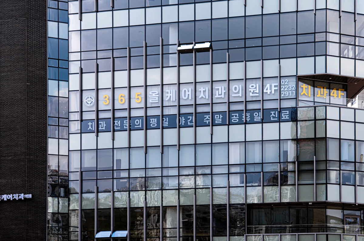 약수역 올케어치과의원 외관 — 4층 통유리 건물의 치과 간판